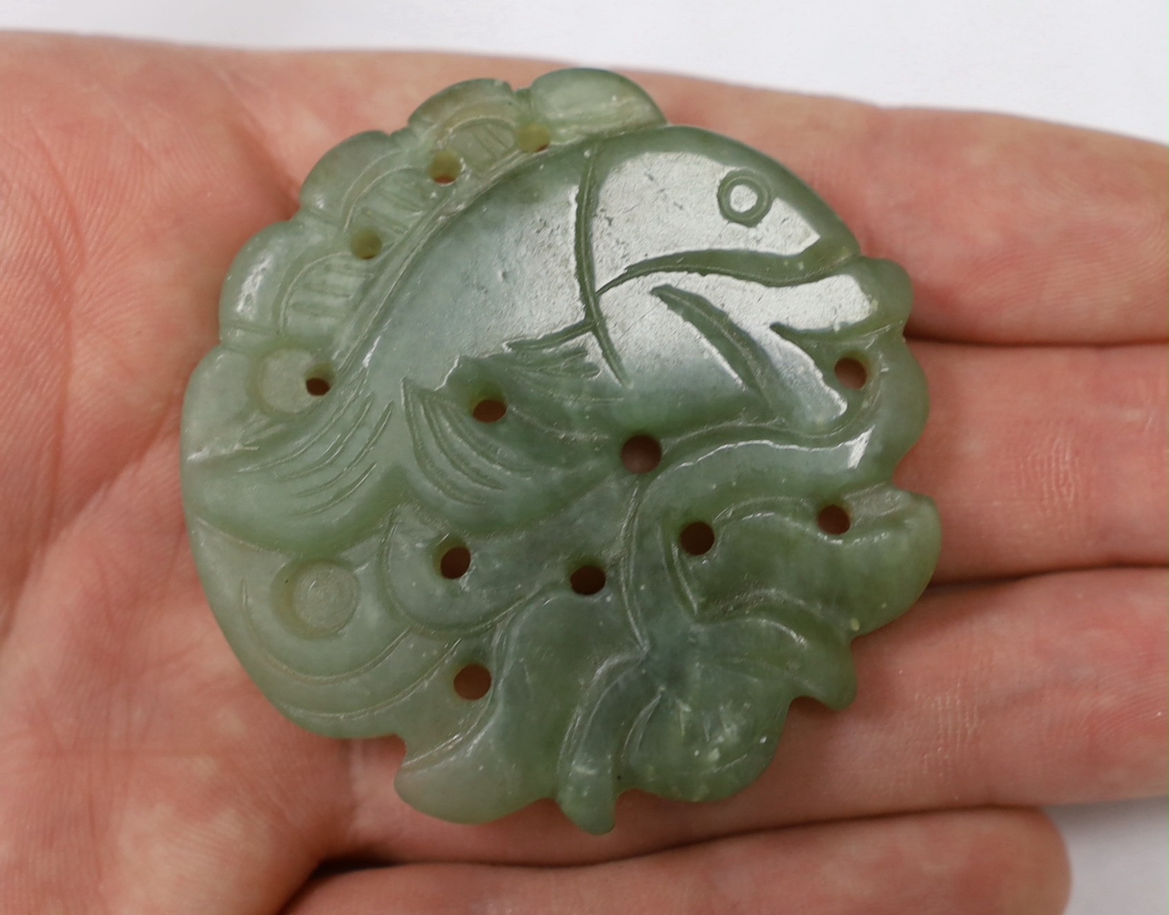 A Chinese carved green hardstone pendant shaped as a fish, 5cm